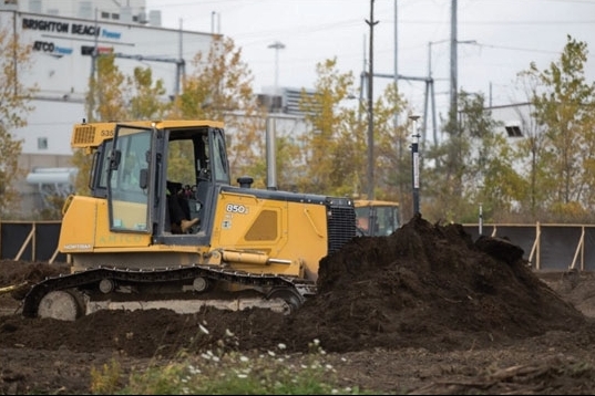 Un bulldozer retirant la couche arable au port d’entrée canadien