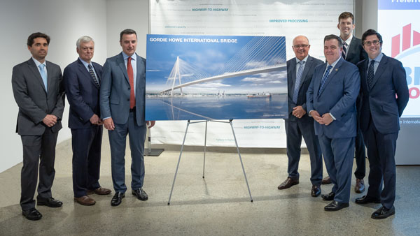 WDBA officials standing next to a rendering of the Gordie Howe International Bridge