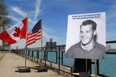 Display showing Gordie Howe along with a Canadian and American flag along the Windsor riverfront